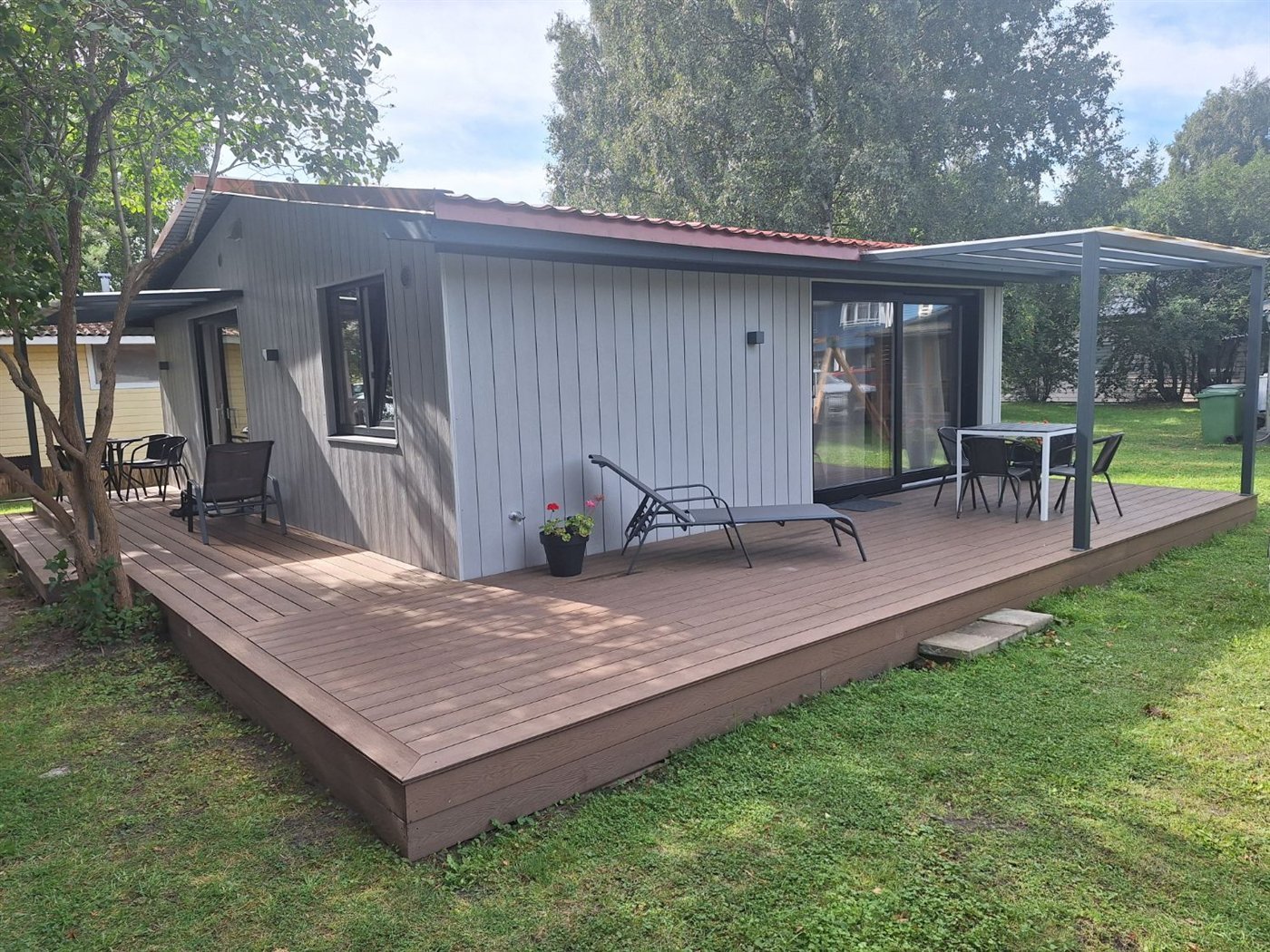 Didelė dengta terasa prie apartamentų